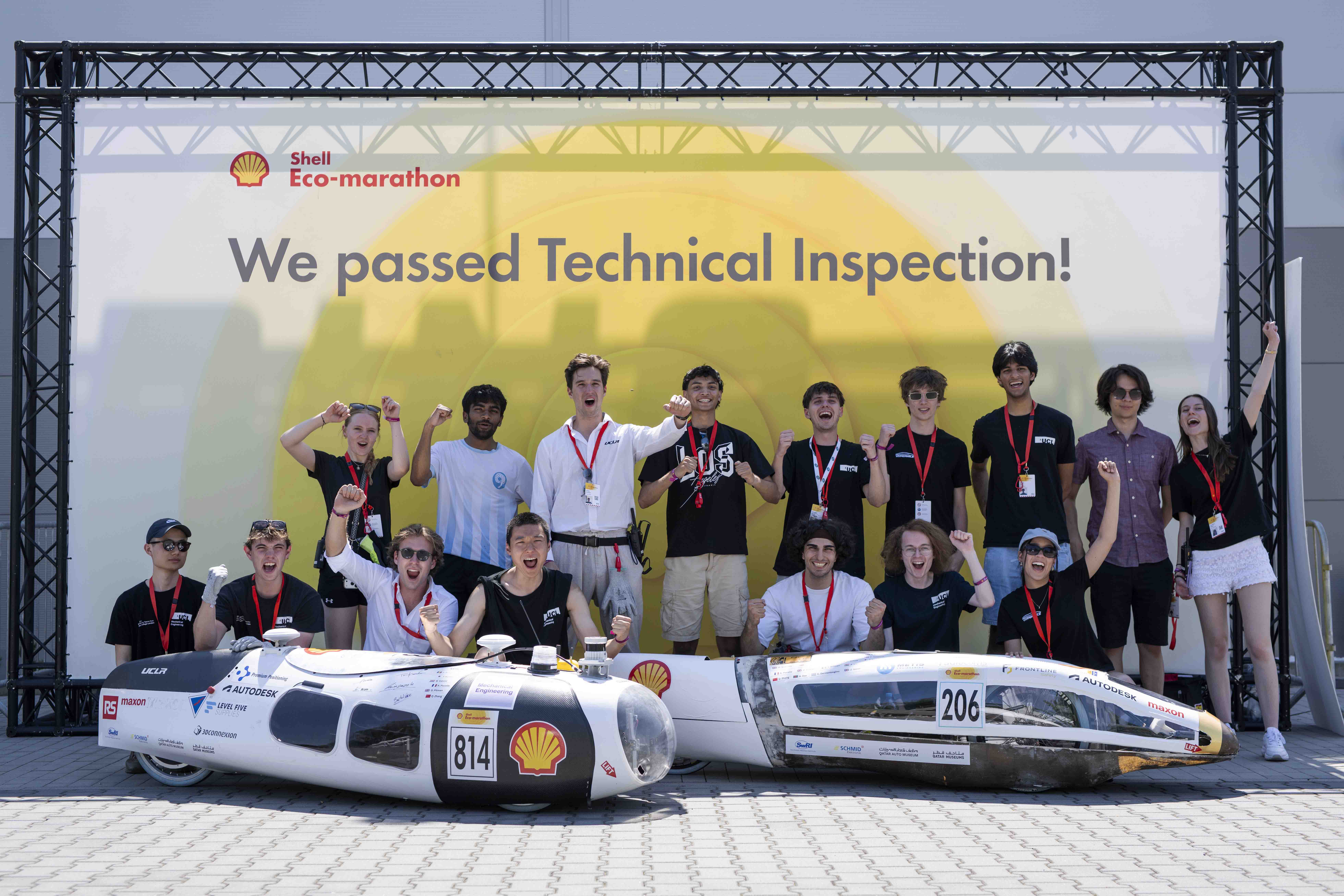 Photo of 2026 team with vehicles in front of Shell Eco-Marathon banner.